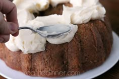 someone is spooning cream on top of a bundt cake