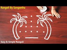 an image of two palm trees drawn on a wooden surface with the words rangoli by sangeetha