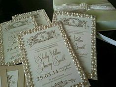 the wedding stationery is decorated with pearls