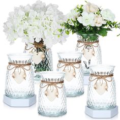 white flowers in glass vases with tags on them