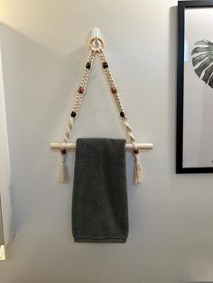 a towel hanging on the wall next to a black and white framed photo with a green towel