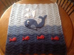 a crocheted blanket with an image of a whale on it