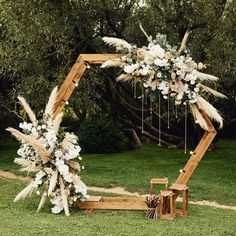 a wooden arch decorated with flowers and feathers