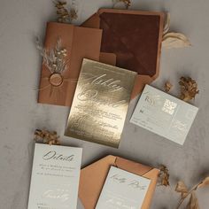 the wedding stationery is laid out on top of each other, with gold foil