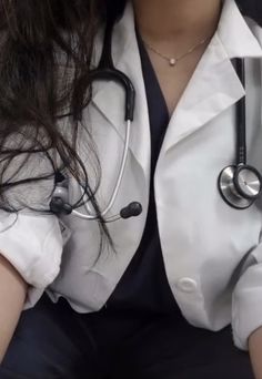 a woman wearing a white coat with a stethoscope on her chest and arm