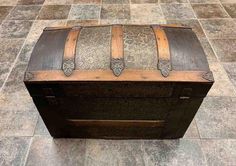 an old trunk is sitting on the floor in front of a tiled flooring area