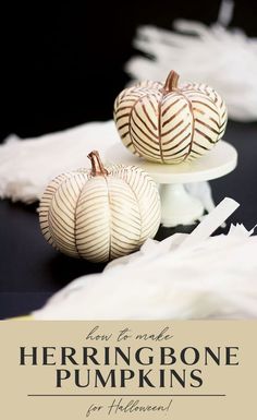 two white pumpkins sitting on top of a cake plate next to some tissue paper