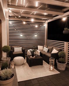 an outdoor living area with couches, chairs and potted plants on the floor