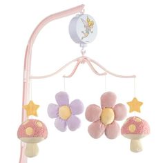 a pink and purple baby crib mobile with mushrooms, stars and flowers on it