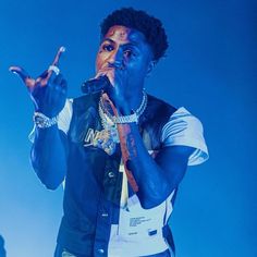 a man that is standing up with his hands in the air and wearing blue paint on his face