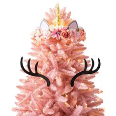 a pink christmas tree with deer antlers and flowers on it's head is shown in front of a white background