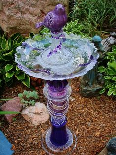 a purple glass bird bath sitting on top of a stand