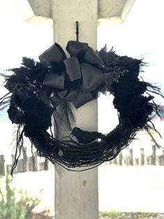 a black wreath hanging from the side of a white building with a bird on it