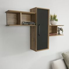 a wall mounted shelf with some books and a book case on top of it next to a couch