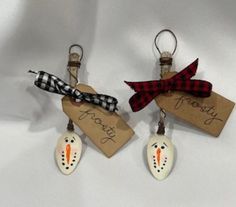 two key chains with tags attached to them that say happy frosty and snowman