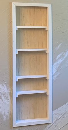 an empty shelf is painted white in a room