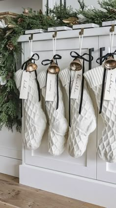 stockings hanging on the wall in front of a christmas tree