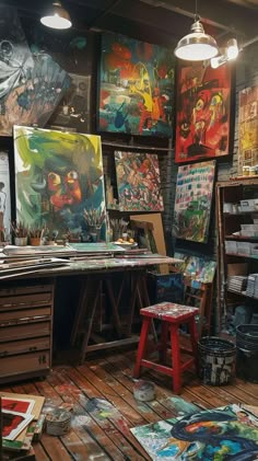 an artist's studio with many paintings on the wall