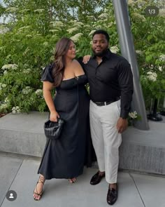 a man and woman standing next to each other in front of a street light pole