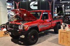 a red truck with an open hood on display