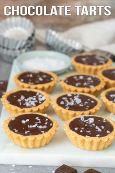 chocolate tarts are lined up on a tray