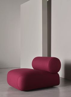 a pink couch sitting in front of a white wall