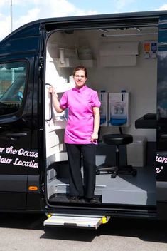 a woman standing in the open door of a van