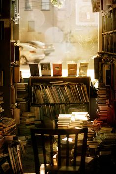 a room filled with lots of books next to a window