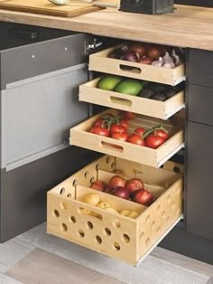 an open drawer in the middle of a kitchen with fruits and vegetables stacked inside it