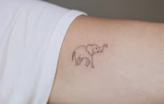 an elephant tattoo on the arm of a woman's left arm, which is drawn in black ink