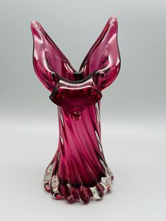 a pink glass sculpture sitting on top of a table