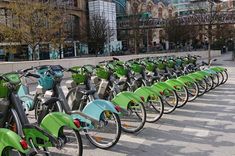 many bicycles are lined up on the sidewalk