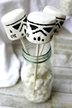 some marshmallows are sitting in a mason jar with the lids decorated to look like darth vader