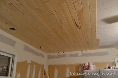 a kitchen with unfinished wood ceiling and cabinets