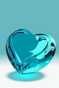 a green glass heart shaped object sitting on top of a table