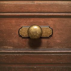 an old wooden drawer with a brass knob on it