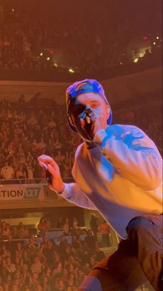 a man standing on top of a stage in front of a crowd