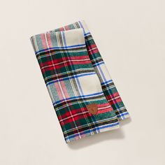 a plaid blanket folded on top of a white table