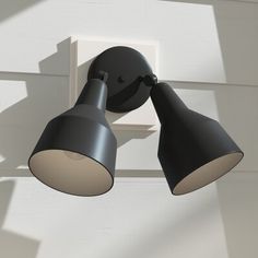 two black lamps on the side of a white wall