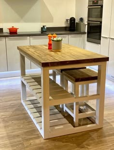 a kitchen island with two stools on it in front of an oven and microwave