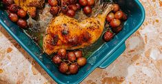 a chicken and grapes in a blue dish