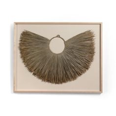 an art piece on the wall with a circular object hanging from it's side