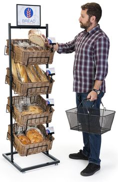 a man standing next to a rack full of bread and pastries with a sign reading bread