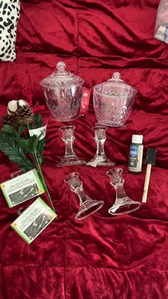 some glass dishes and other items on a red blanket