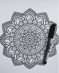 a pen is sitting on top of a paper with an intricate design in the middle