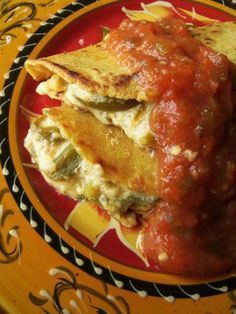 a plate with some food on it sitting on a yellow and black table cloth,