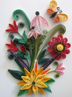 colorful paper flowers are arranged on a white surface