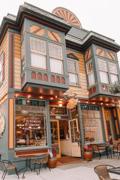 an old building with many windows and tables outside on the sidewalk in front of it