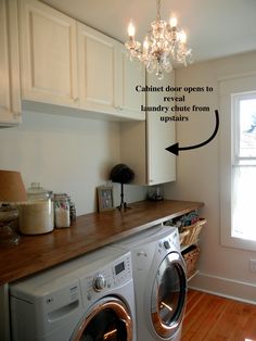 Beautiful laundry room with folding counter, hidden laundry chute, and crystal chandelier. Laundry Room Chute Ideas, Laundry Room With Chandelier, Chandelier In Laundry Room, Hidden Laundry Chute, Laundry Room Shoot Ideas, Laundry Shoot Ideas Bathroom, Hidden Laundry Shoot Ideas, Hidden Laundry Shoot, Laundry Shoot Cabinet