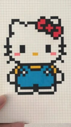 someone is holding up a cross stitch hello kitty sticker in front of their face